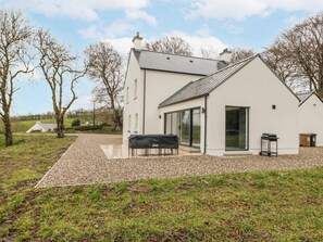 A modern house with a large patio, a barbecue, and a covered outdoor seating area. - Cloneytrace Mines, Broughshane (Ballymena)