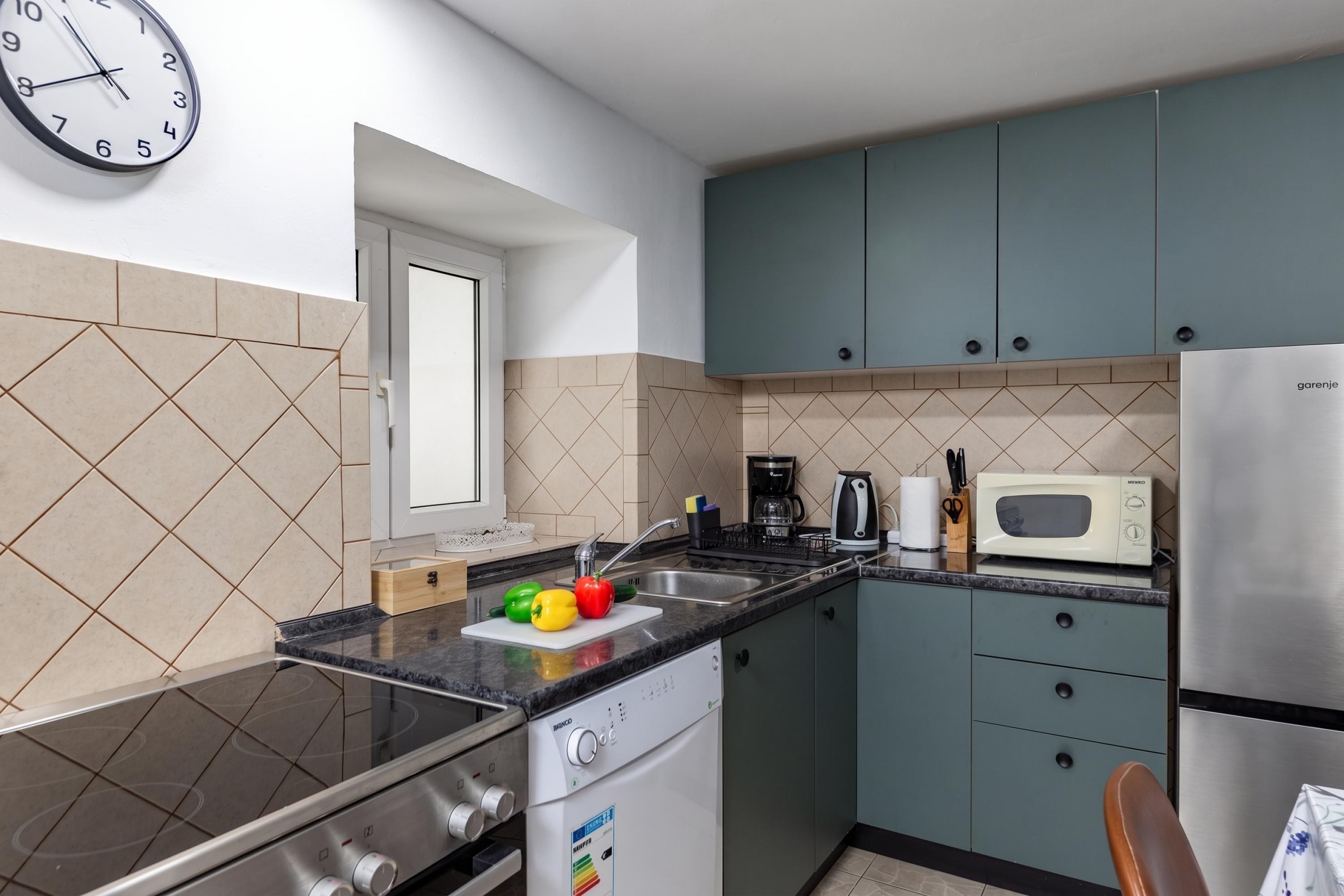A compact kitchen with a stove, microwave, and cabinets.