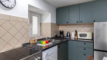 A compact kitchen with a stove, microwave, and cabinets.