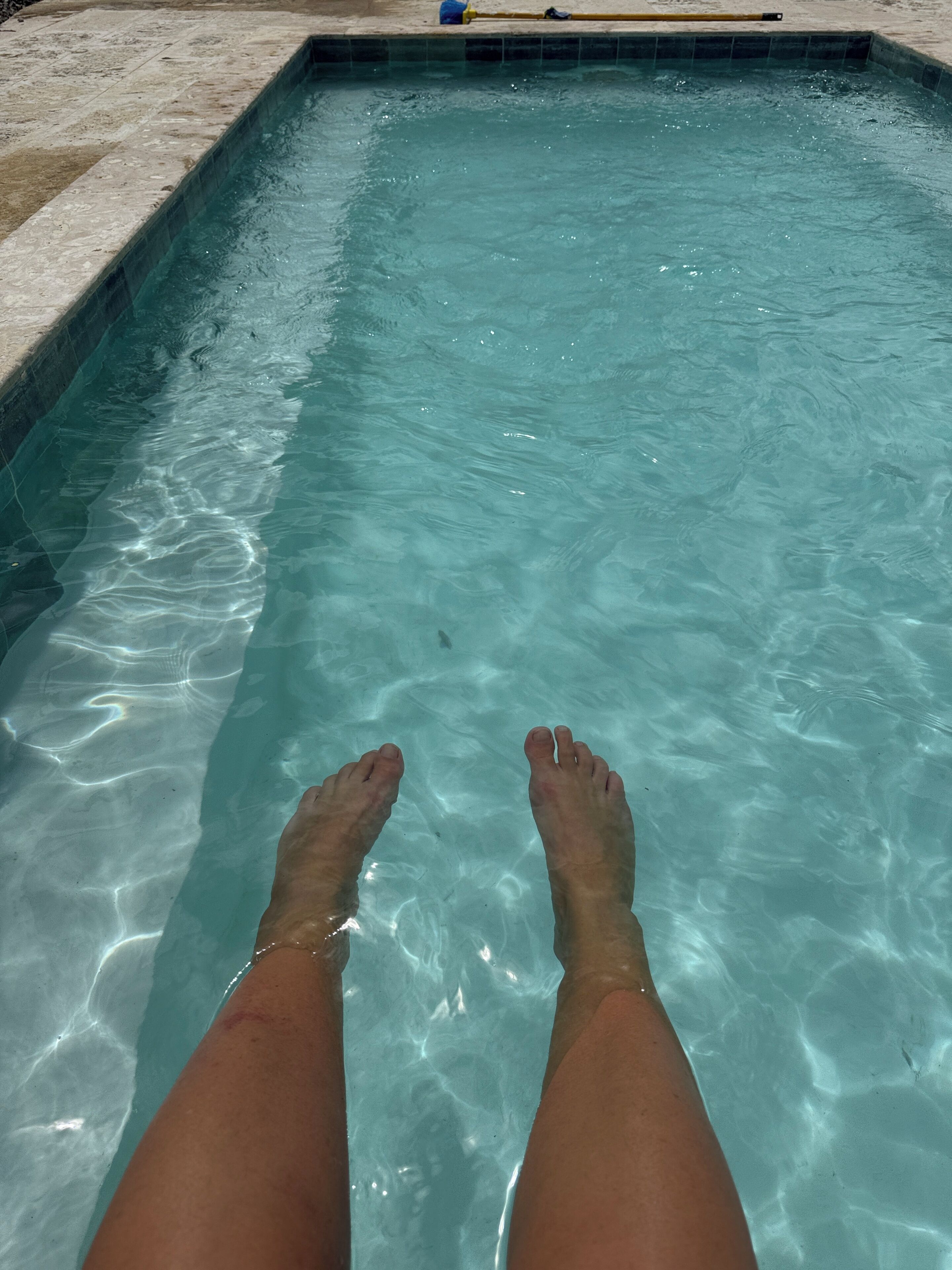 Ein Pool mit klarem Wasser und einer gefliesten Kante.