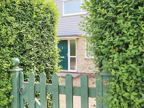 A house with a green door, a stone wall, and a wooden fence. - The Garden House in Whitstable (Whitstable)