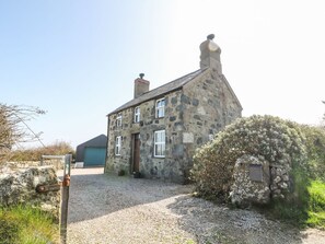A stone house with a gravel driveway, a small shed, and a metal gate. - Charming Bod Rhiw Retreat in Aberdaron (Pwllheli)