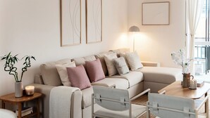 A living room with a sofa, a side table with a candle, and a lamp. - Ruan Downtown - MyHomeinComo (Como)