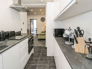 A modern kitchen with a stove, oven, and countertop. - Flat 1, Mona House, Deganwy (Conwy)