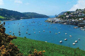 A coastal town with boats on the water, buildings on the hills, and greenery. - Joymead: Charming Retreat in Malborough (Kingsbridge)