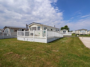 A row of mobile homes with white railings and a grassy lawn. - Lawi39: Charming Retreat in Towyn (Abergele)