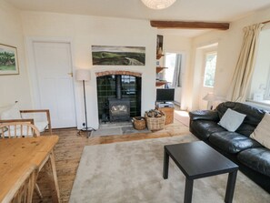 A living room with a fireplace, a sofa, a table, and a lamp. - Low Muffles Bridge, Pickering (Pickering)