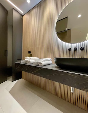 A modern bathroom with a black sink, a large mirror, and a towel rack. - Elegant apartment in the historic center of Verona (Verona)
