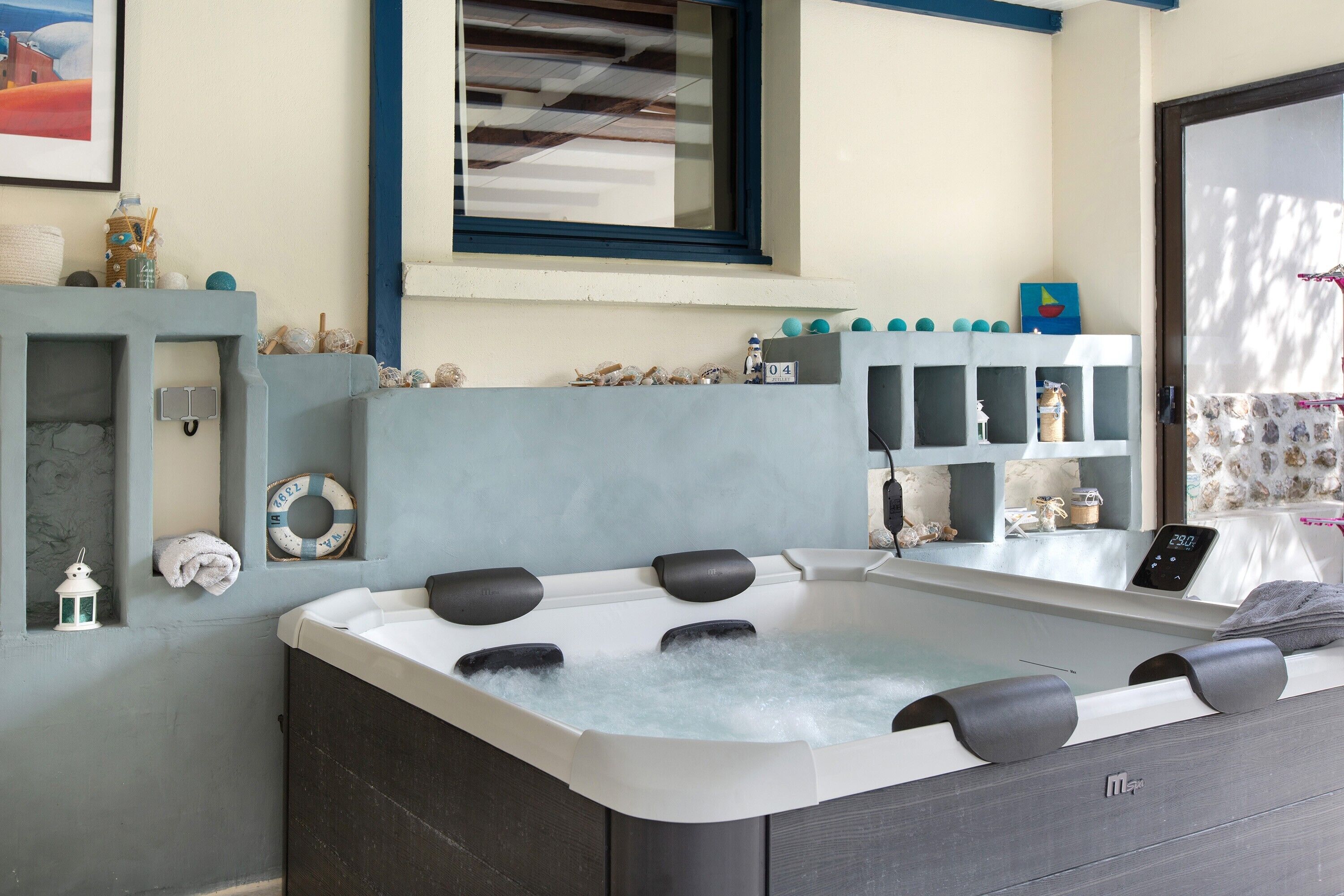 Un espace bien-être avec un jacuzzi, une fenêtre offrant une vue agréable et une décoration sur le thème de la mer.