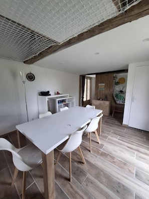 A modern kitchen with white cabinets, a wooden countertop, and a hanging light fixture. - Gîte Ressources: Jacuzzi, Private Terrace & Garden (La Frénaye)