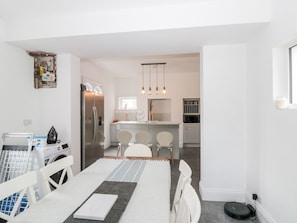 A compact kitchen with a refrigerator, sink, and dining area with chairs. - Castle Manor is in Scarborough (Scarborough)