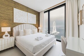 Ein modernes Hotelzimmer mit einem großen Bett, einem Schreibtisch und Blick auf die Stadt.