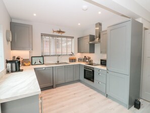 A modern kitchen with grey cabinets, a built-in oven, and a window with blinds. - 41 Chatsworth Gardens, 4 beds. (Scarborough)
