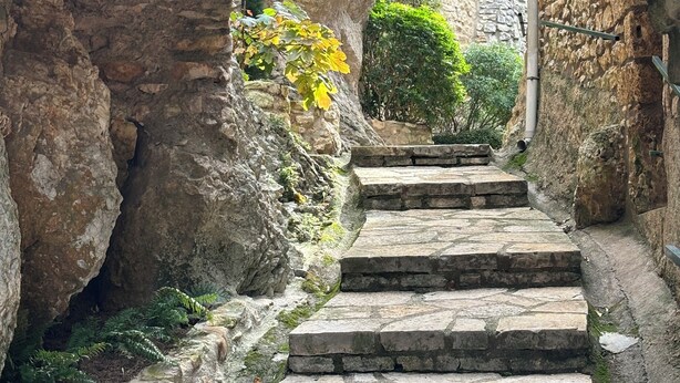 Una scala in pietra che conduce attraverso una struttura ad arco in pietra.