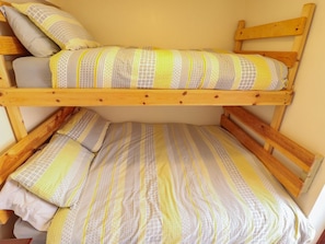Un lit superposé avec une couvre-lit et des oreillers à motifs.