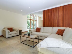 A modern living room with a sectional sofa, a coffee table, and a large window. - Heathcliffe House, Cardiff (Cardiff)