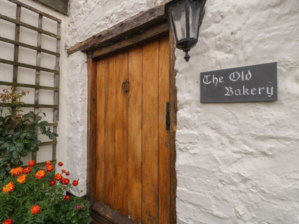 A wooden door with a sign above it reading 'The Old Bakery.'