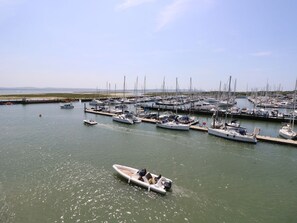A marina with multiple boats docked, a small motorboat in the foreground, and a clear sky.