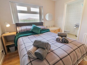 A bedroom with a bed, bedside table, lamp, window, and a view of the outdoors. - Ritas, nr Kilkeel, County Down (Newry)