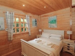 A wooden-paneled bedroom with a bed, nightstands, and a window with curtains. - Pine, Swanage, Dorset AONB, TV (Swanage)