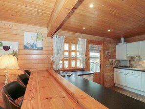 A wooden interior with a dining area, kitchen, and a window with curtains. - Pine, Swanage, Dorset AONB, TV (Swanage)
