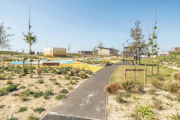 A pathway leading to a pool area with a building in the background.