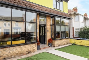 A two-story building with large windows, a brick facade, and a number '287' on the door. - The Yellow House in Withernsea (Withernsea)