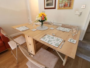 A dining table set with place settings, a vase of flowers, and a chair. - Valley View Cottage Holmbridge (Holmfirth)