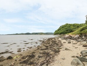 A beach with rocky shoreline, seaweed, and distant hills. - Crinan Canal Cottage, Kilmartin (Lochgilphead)