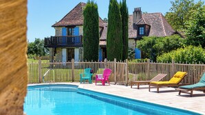 Une piscine avec des chaises longues et une clôture en bois.