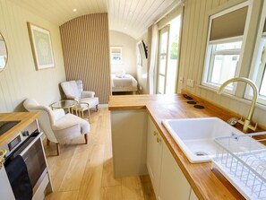 Una cocina compacta con lavabo, estufa y zona de estar.
