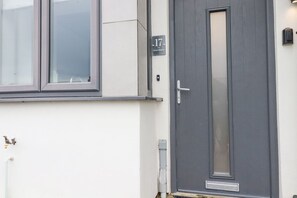 A building with a grey door, a window, and a number plate reading '17'. - 17 Ocean Heights is in Newquay (Newquay)