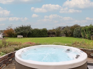 A hot tub in a backyard with a lawn, trees, and a wooden deck. - The Old Manor House, Lifton (Lifton)