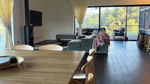 Una sala de estar moderna con una mesa de comedor de madera, un sofá y un ventilador de techo.