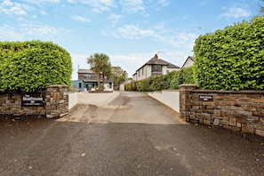 A gated driveway leading to a residential property with a sign indicating 'The Boathouse Holiday Home.' - Sea Haze Retreat in Tenby (Tenby)