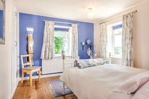 A bedroom with a bed, a chair, a radiator, and a window with curtains. - Cabbage Hall Cottage, Wetherby (Wetherby)