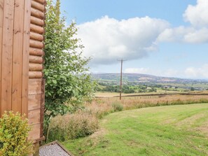 A wooden cabin with a view of rolling hills and a power line in the distance. - Bracken Hut at Copy House Hideaway, Earby (Barnoldswick)