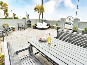 A rooftop terrace with seating, a grill, and a gate. - Wavecrest: Coastal Retreat in Pwllheli (Pwllheli)
