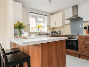 A modern kitchen with a central island, a stove, and a window. - Dartmoor Valley Lodge, Gunnislake (Callington)