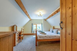 A bedroom with a wooden bed, a desk, and a chair. - Charming Maesgwyn Retreat in Beguildy (Knighton)
