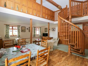 A spacious loft-style room with a dining area, a sofa set, a wooden staircase, and a lofted wooden ceiling. - Charming Barn Owl Retreat in Louth (Louth)