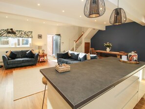 Ein modernes Wohnzimmer mit einer Couch, einem Couchtisch und einem Essbereich mit einem Holztisch.