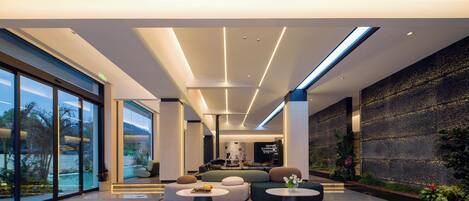 A modern lobby with a seating area, large windows, and a decorative wall.