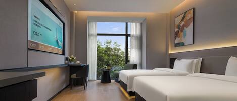 Une chambre d’hôtel moderne dotée d’une grande télévision, de deux lits, d’un bureau et offrant une vue sur la verdure par la fenêtre.