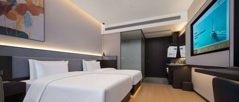 A hotel room with two beds, a TV, a painting, and a desk.