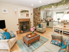 Una sala de estar acogedora con chimenea, comedor y cocina.