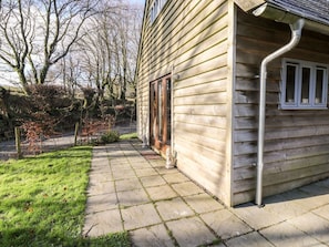 Une maison en bois avec un chemin de pierre menant à l’entrée.