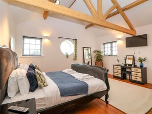 A bedroom with a bed, a desk, a TV, and a window. - The Wing, Bangor-On-Dee, Wales (Wrexham)