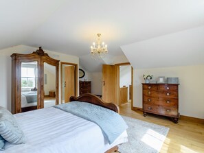 Ein Schlafzimmer mit Bett, Schminktisch und einer Chandelüster.