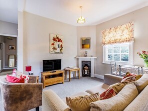 A living room with a fireplace, a television, and a sofa.